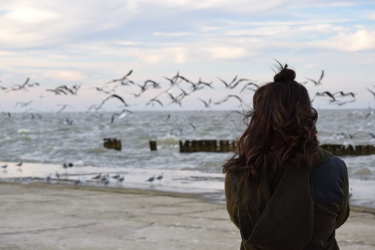 Girl on beach looking at seagulls - ADHD
