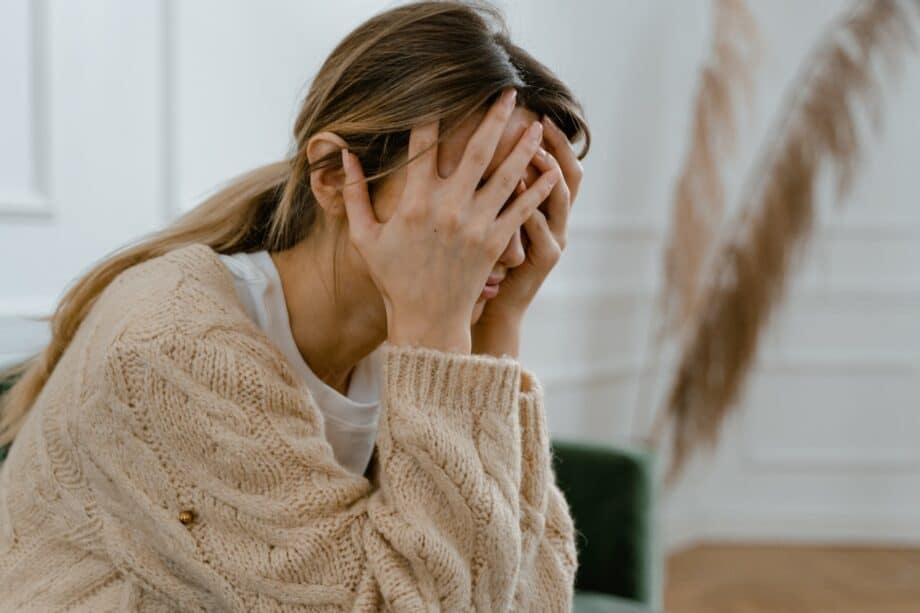 Woman with ADHD holding head in hands