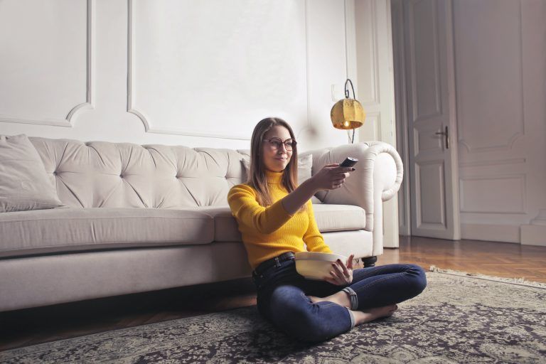 3 woman sitting on floor using remote control